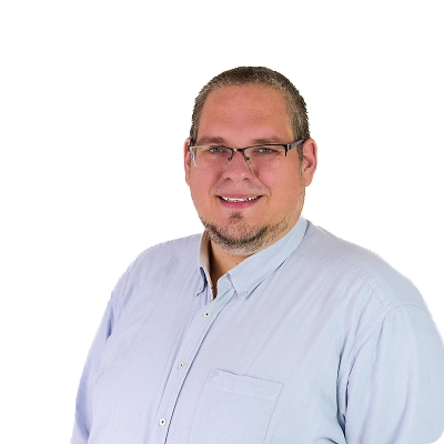 Daniel Wandel: Mann mit kurzem Haar und Brille, trägt hellblaues Hemd, steht leicht seitlich zur Kamera.