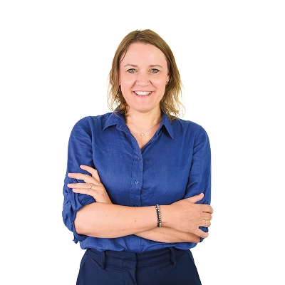 Marion Bess: Frau mit schulterlangen Haaren, trägt dunkelblaues Hemd, verschränkt die Arme.